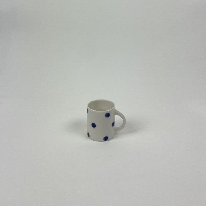 Candy cup fra Anne Black i en hvid farve med mørkeblå prikker på. Denne er den mindste, som der lige kan være en espresso i
