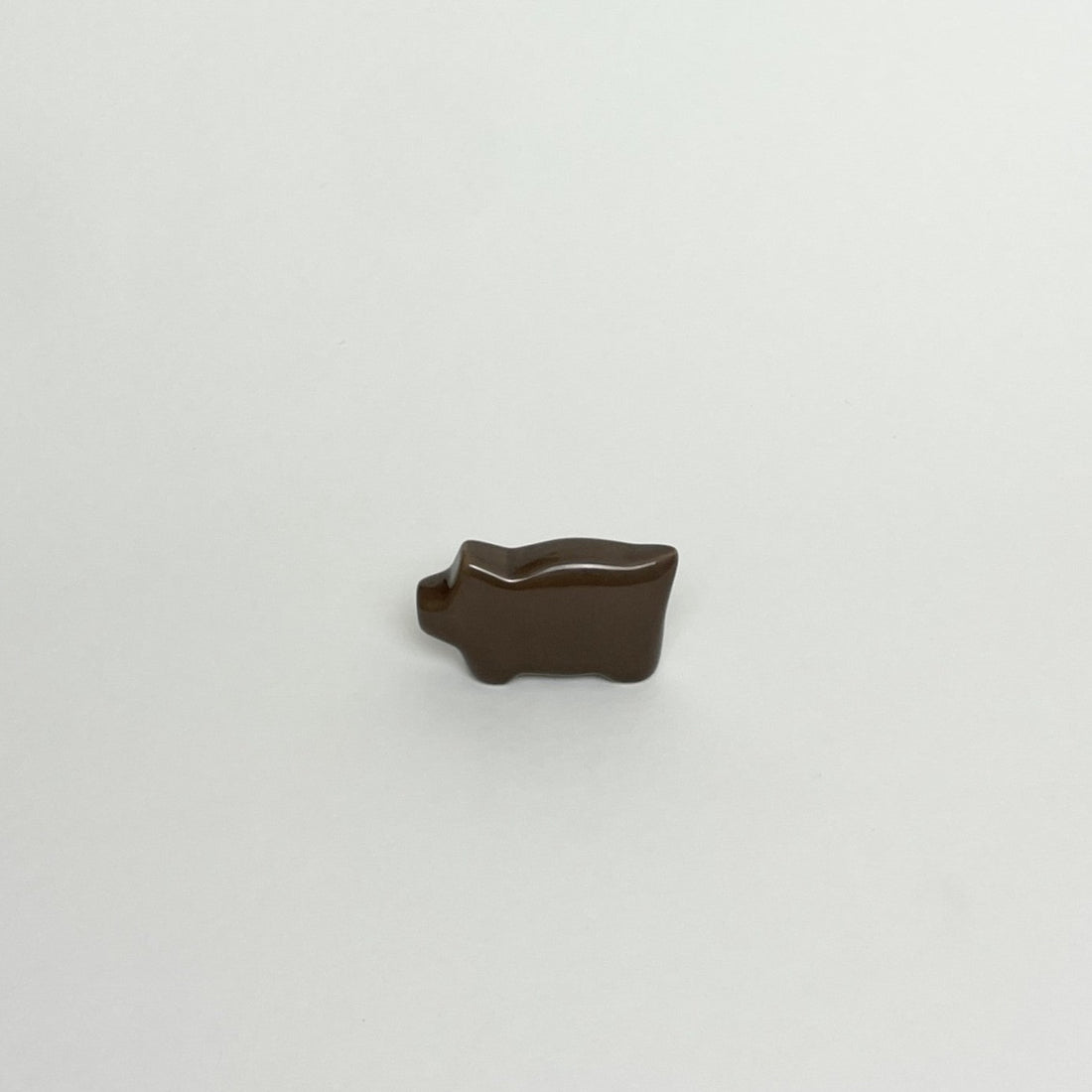 En julegris i mørkebrun i keramik fra Anne Black