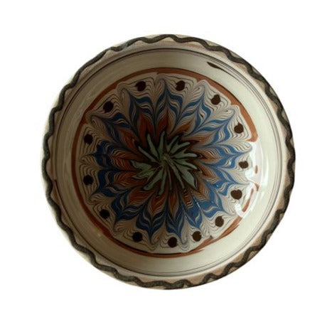 Rumænsk keramikskål fra Jou Quilts. Skålen er beige farvet med brun, blå og grøn farvet mønster i sig
