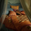 Et dug/sengetæppe med ternet mønster i beige og brun samt en orange og pink kant