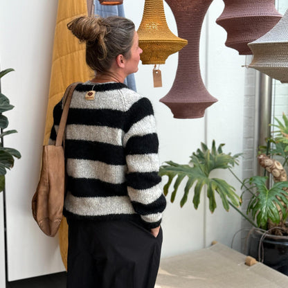 Ida Striktrøjen fra Coffee Beanies er en klassisk striktrøje med rund hals og lange ærmer. Trøjen er lavet i 100% blød alpakauld og er onesize. Denne er i grå og sort strib.