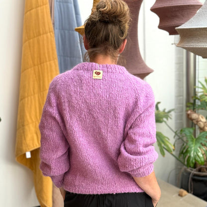 Lyserød striktrøje fra Coffee Beanies lavet af kvinder i afrika. Denne er lyserød og i 100% alpakauld