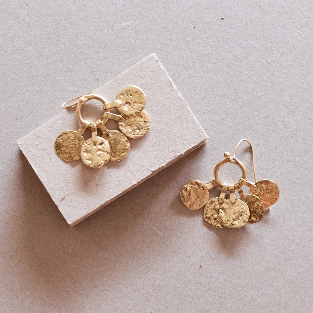 Floos Øreringene fra Hamimi er et par marokkanske øreringe i messing, hvor en rund ring har flere små mønster hængende ned. Perfekt til festlige begivenheder!