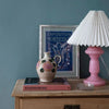Petro 1, fra den danske virksomhed Pink Rose, er en klassisk glaslampe. Den er mundblæst, og denne farve 'rosa opal' er i en fin lyserød farve. Her er den parret med en hvid lampeskærm