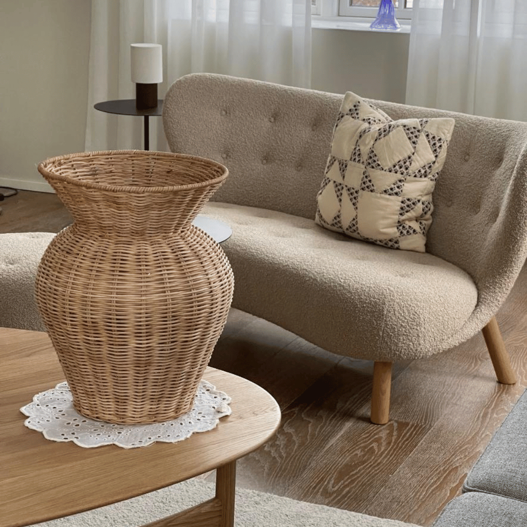 Dekorativ stor vase i flettet rattan, ideel til tørrede grene eller som skulpturelt element i hjemmet.