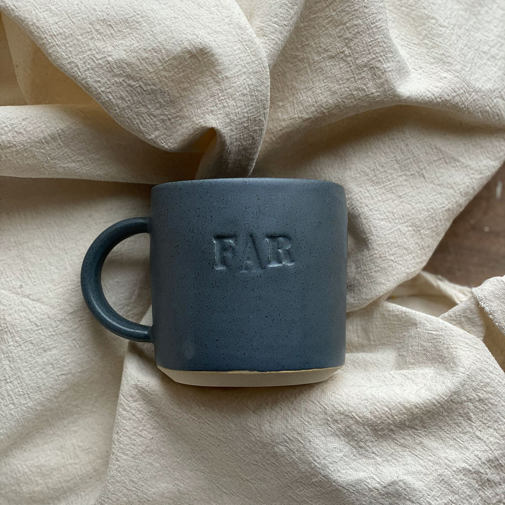 'FAR' koppen fra julie damhus er en traditionel kop med hank, hvor ordet 'FAR' står på fronten. Denne er i farven blå