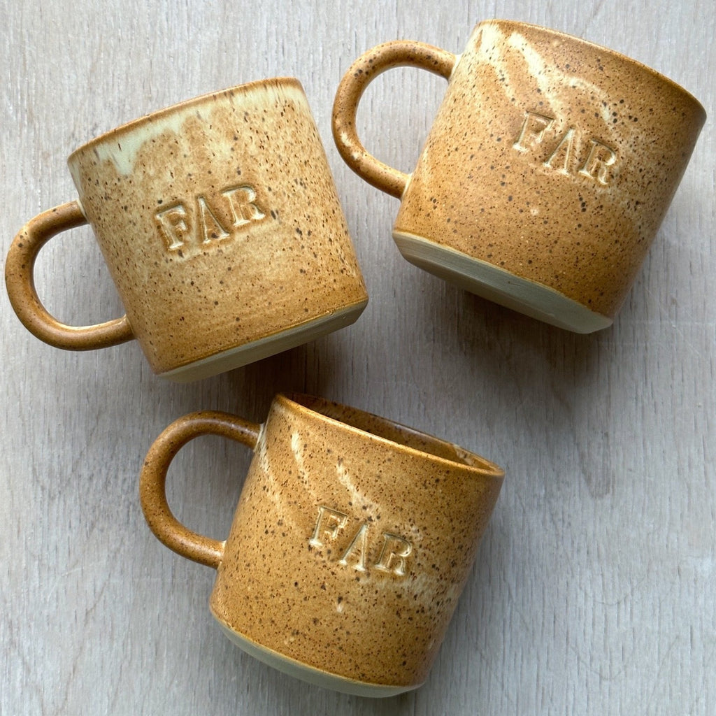 'FAR' koppen fra julie damhus er en traditionel kop med hank, hvor ordet 'FAR' står på fronten. Denne er i farven brun