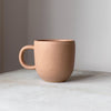 Oktober koppen fra Julie Damhus er en kaffekop med hank og i en enkelt farve. Denne er i farven 'latte', som er en lys brun farve