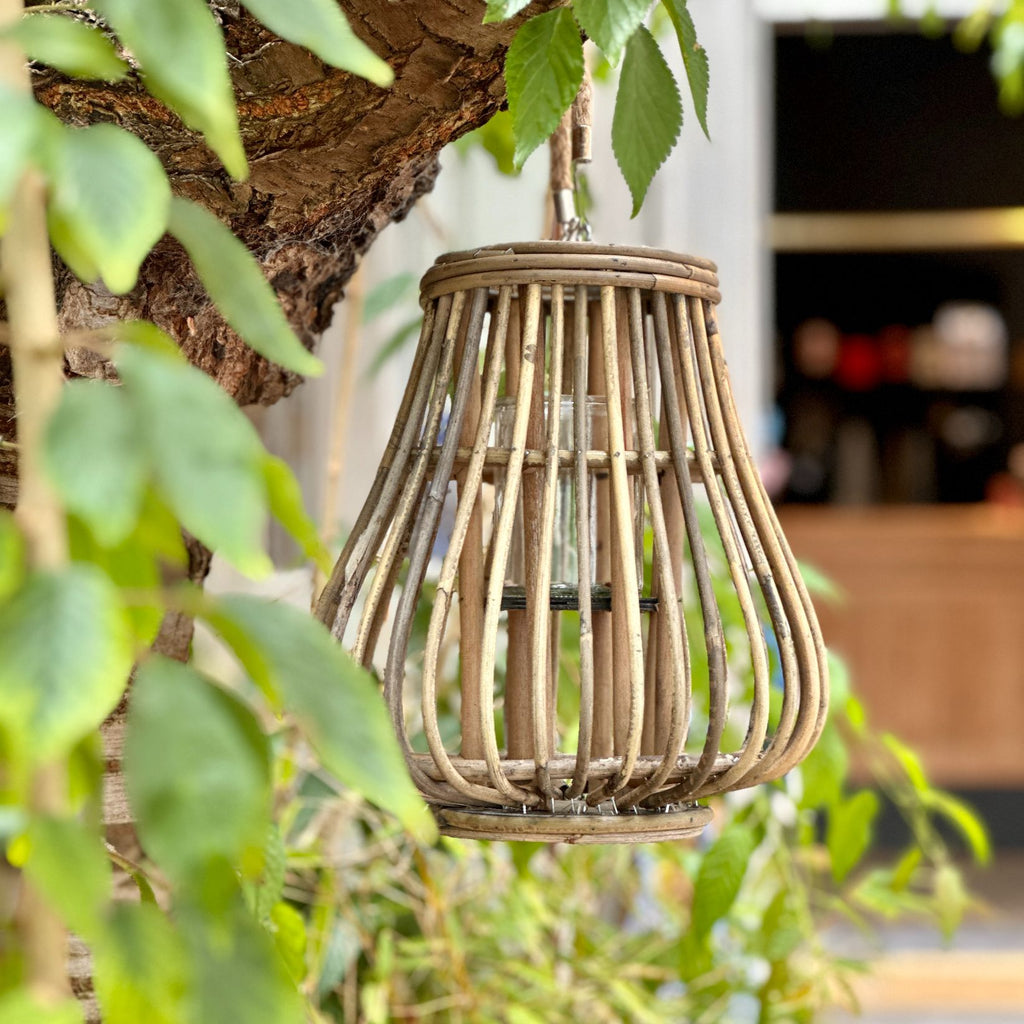 De dråbeformede rattan lanterner er en charmerende tilføjelse til enhver udendørs eller indendørs indretning. Lanternerne er lavet af rattan, som er et naturligt materiale, der giver dem et rustikt og boheme-inspireret udseende. Her ses den lille