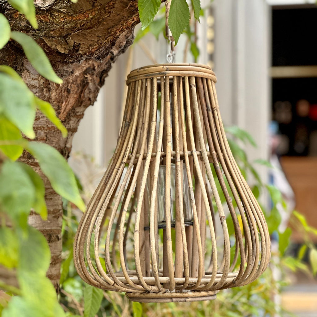 De dråbeformede rattan lanterner er en charmerende tilføjelse til enhver udendørs eller indendørs indretning. Lanternerne er lavet af rattan, som er et naturligt materiale, der giver dem et rustikt og boheme-inspireret udseende. Her ses den mellem