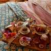 Et dug/sengetæppe med et blå blomstermønster i midten og en pink kant