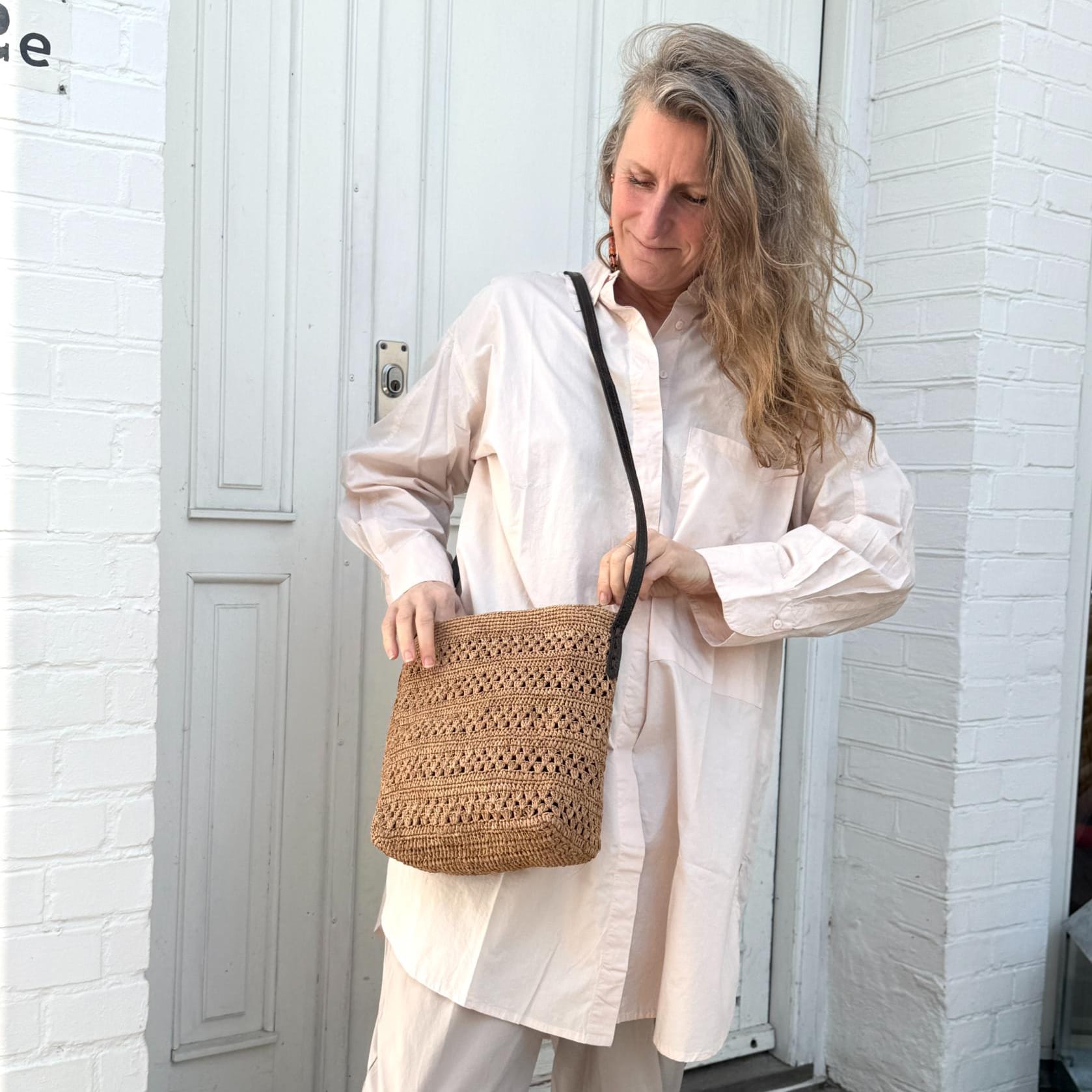 Brun flettet crossbody taske med sort rem stylet til et lyst og afslappet outfit