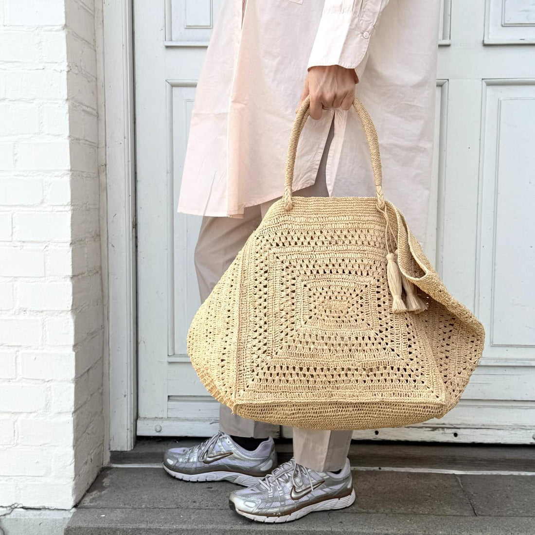 Håndlavet taske i naturmateriale med detaljeret flet og afslappet sommerlook