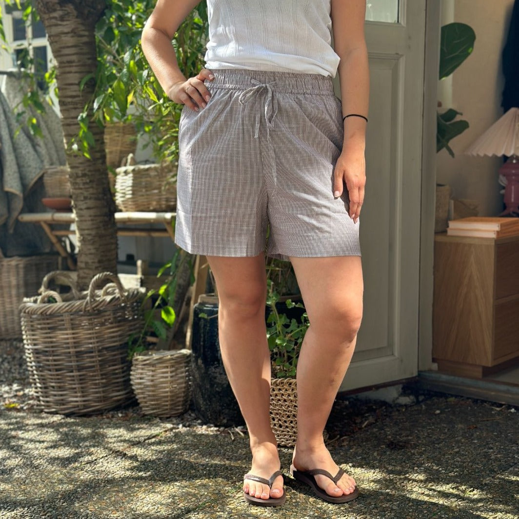 Sydney Shorts er endnu en tidløs klassiker til din garderrobe fra danske Frau. Shortsene er lavet i et enkelt design med vide ben, baglommer, bred elastik i taljen og bindebånd.  Disse er i en brun og hvid strib