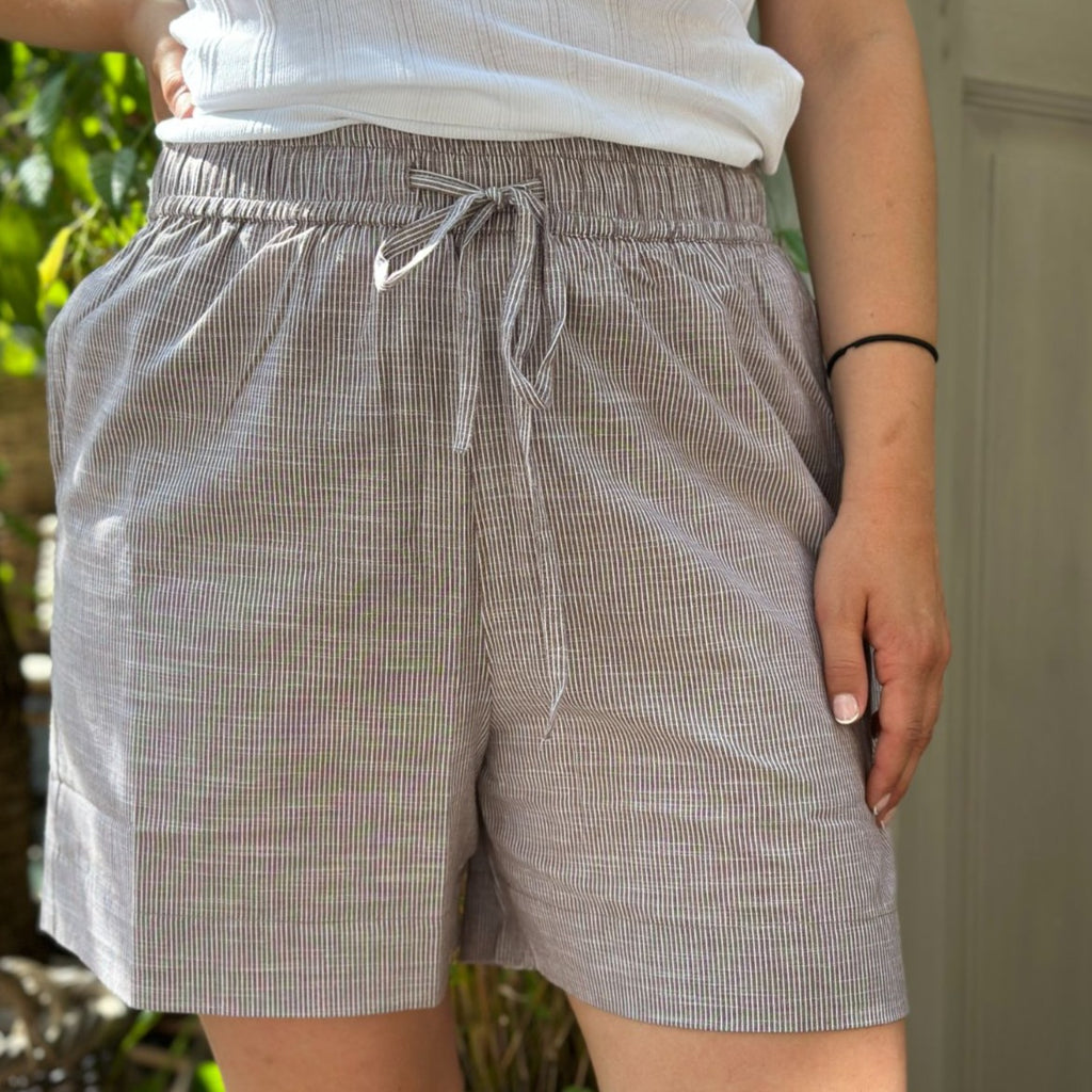 Sydney Shorts er endnu en tidløs klassiker til din garderrobe fra danske Frau. Shortsene er lavet i et enkelt design med vide ben, baglommer, bred elastik i taljen og bindebånd.  Disse er i en brun og hvid strib