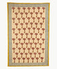 Et dug/sengetæppe med et mønster af brune og lyserød palmer på en beige baggrund i midten og en blå og gul mønstret kant