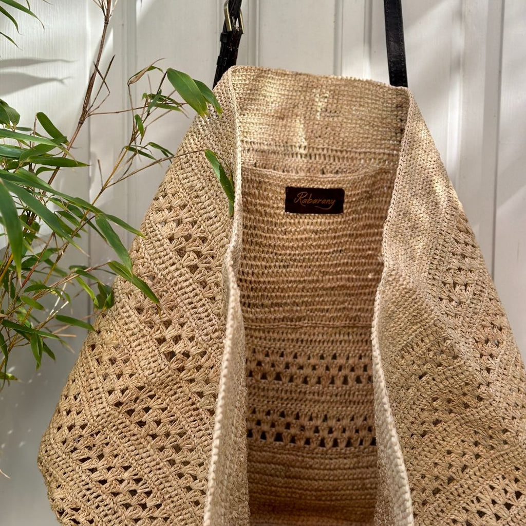 Malette bag er en stor taske i raffia med læderstropper. Denne er i farven Lys natur