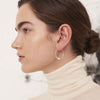 Kvinde med store FLORA hoops øreringe, i dråbeform, lavet af sterling silver, fra Studio Loma