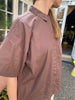 Den brune kortærmede 'Nice' skjorte fra Frau er en tidløs klassiker til garderoben. T-shirten skjorten har stolpelukning, og er lavet i en let bomuldspoplin, som gør skjorten åndbar og super behagelig at have på. Modellen er one size og er lavet i 100% økologisk bomuld.
