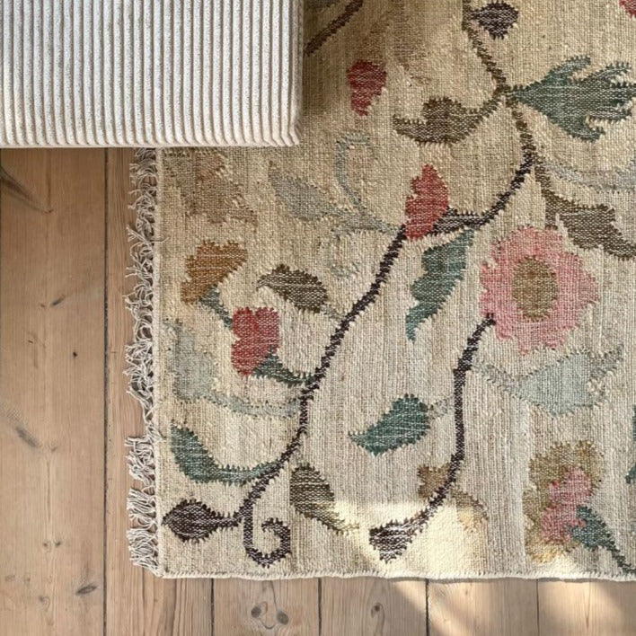 Jute kelim gulvtæppet Flora har en flot farve kombination af naturlige gule, grønne og rosenfarvede nuancer, der med det traditionelle kelim mønster giver tæppet et smukt og blødt look.