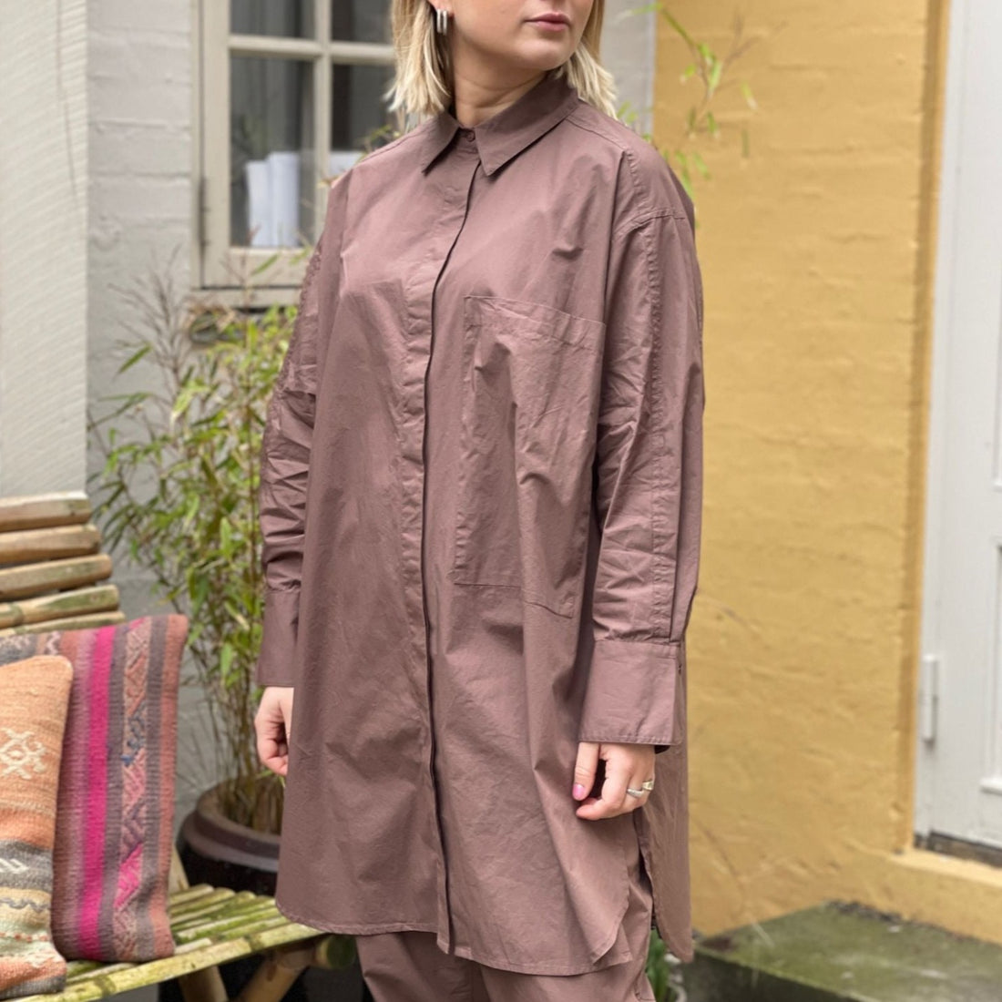 Den lange brune bomuldsskjorte i er en perfekt hverdagsskjorte fra Frau. Skjorten er lidt længere bagpå og runder fint foran. Skjorten er gennemknappet, og er lavet i økologisk bomuldspoplin, som gør den åndbar og behagelig at have på. Størrelsen er one size