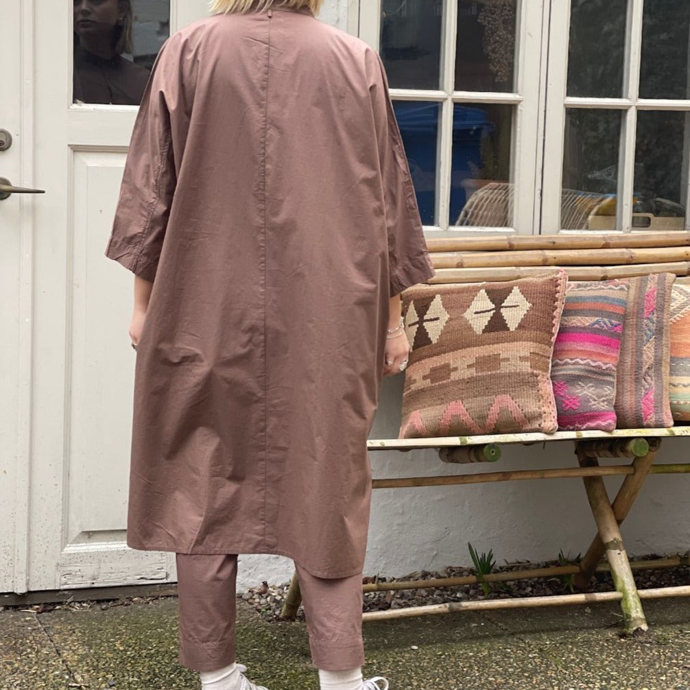Vi er helt vilde det fine snit på den lange brune skjorte Seoul fra danske Frau, den oversized skjorte kjolen har 3/4 ærmer og en simpel kinakrave, der giver den et lækkert casual look. En anden skøn detalje er, at den har sidelommer. Modellen er one size og er lavet i 100% økologisk bomuld