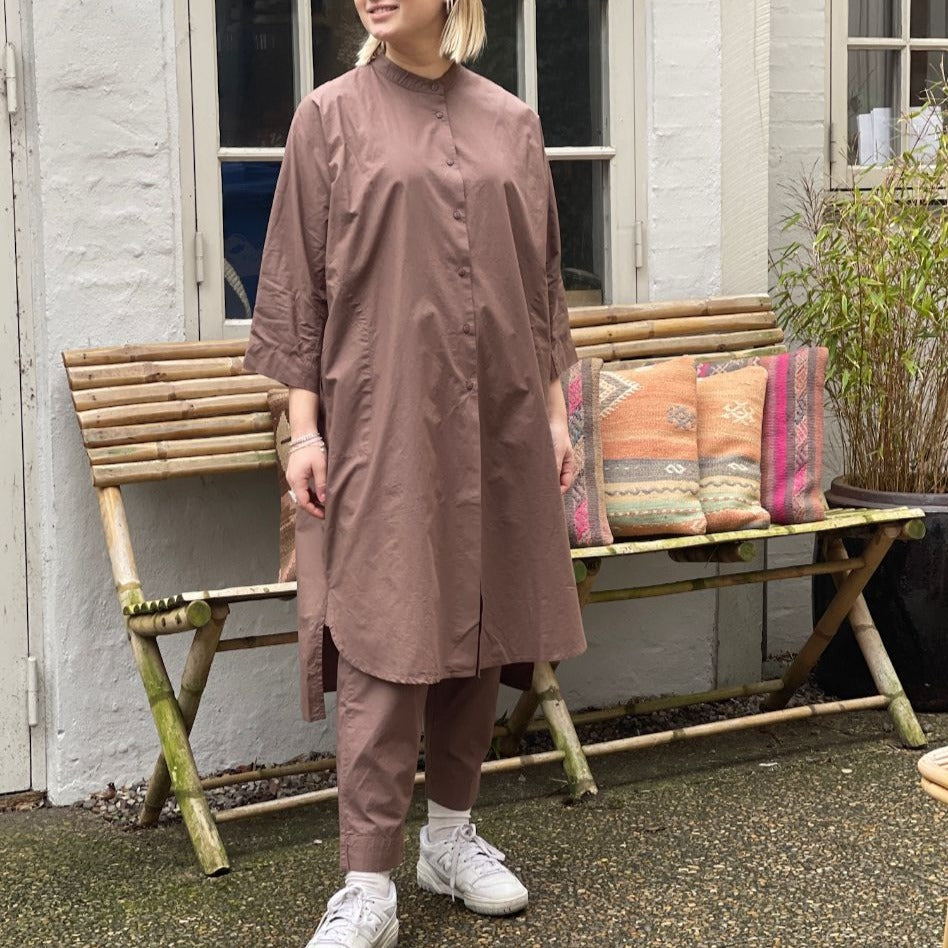 Vi er helt vilde det fine snit på den lange brune skjorte Seoul fra danske Frau, den oversized skjorte kjolen har 3/4 ærmer og en simpel kinakrave, der giver den et lækkert casual look. En anden skøn detalje er, at den har sidelommer. Modellen er one size og er lavet i 100% økologisk bomuld.
