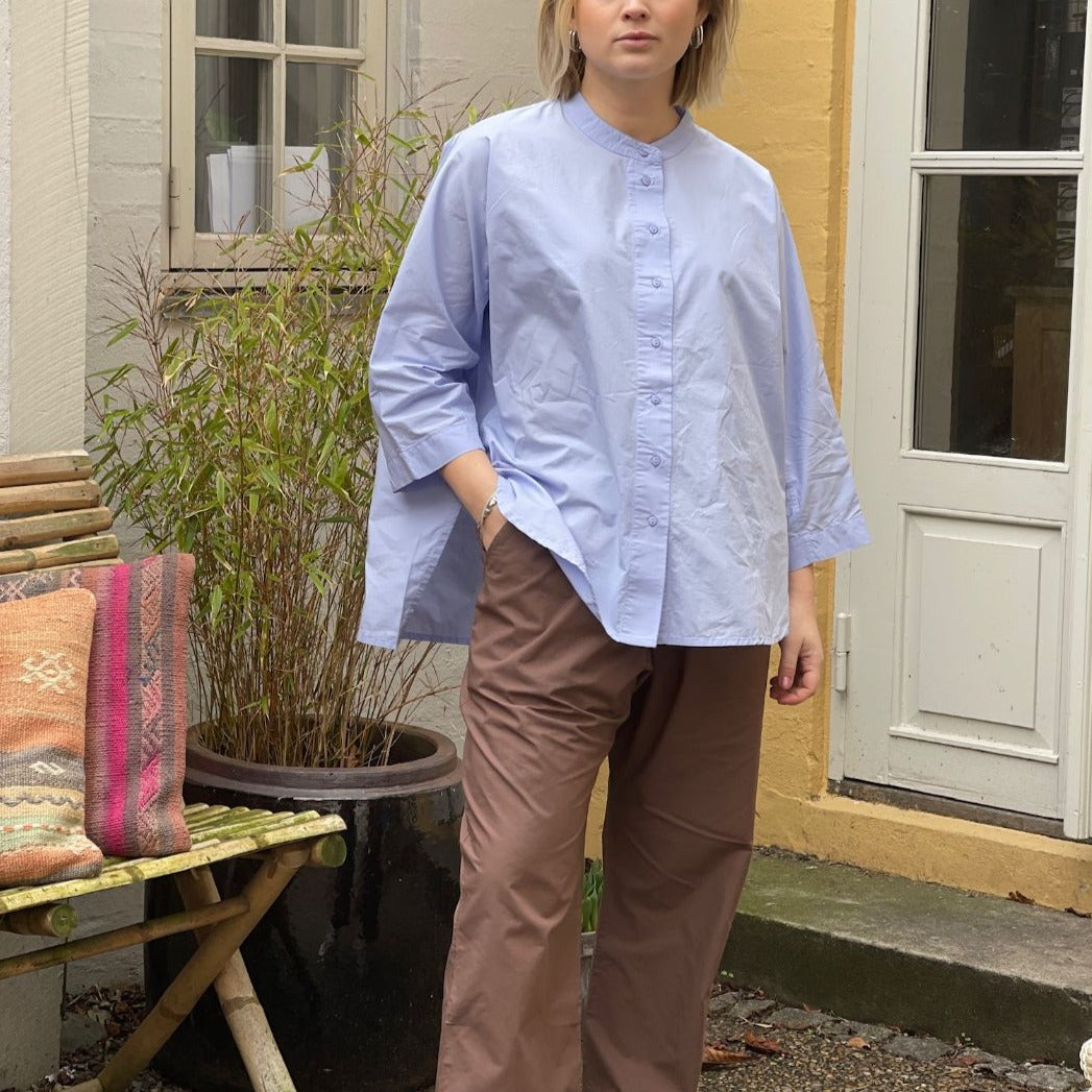 Lyseblå oversized skjorte i enkelt design med 3/4 ærmer og kinakrave. Skjorten er lidt længere bagpå og runder fint foran. Skjorten har stolpelukning, og er lavet i en let økologisk bomuldspoplin, som gør skjorten åndbar og behagelig at have på. Skjorten er one size og passer str 34-44.
