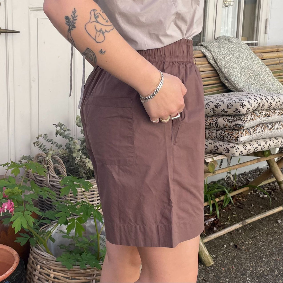 De nye Sydney Shorts i mørkebrun er endnu en tidløs klassiker til din garderobe fra danske Frau. Shortsene er lavet i et enkelt design med vide ben, baglommer, bred elastik i taljen og bindebånd.