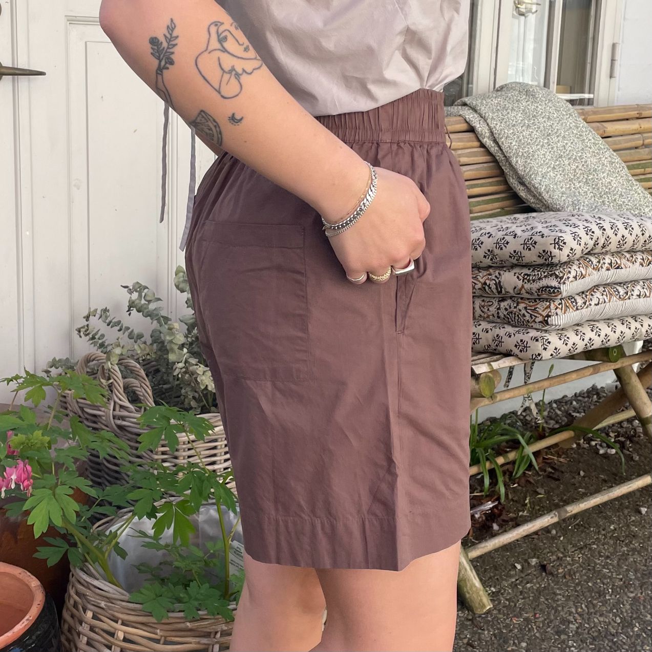 De nye Sydney Shorts i mørkebrun er endnu en tidløs klassiker til din garderobe fra danske Frau. Shortsene er lavet i et enkelt design med vide ben, baglommer, bred elastik i taljen og bindebånd.