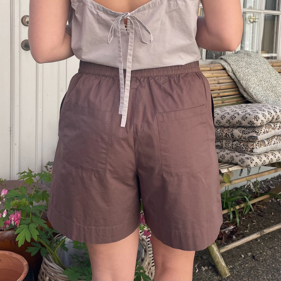 De nye Sydney Shorts i mørkebrun er endnu en tidløs klassiker til din garderobe fra danske Frau. Shortsene er lavet i et enkelt design med vide ben, baglommer, bred elastik i taljen og bindebånd.