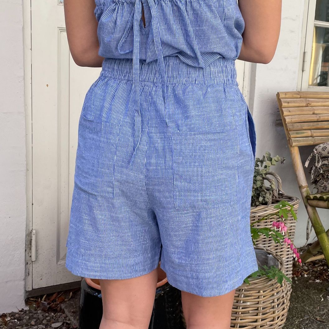 De nye Sydney Shorts i stribet blå og hvid er endnu en tidløs klassiker til din garderobe fra danske Frau. Shortsene er lavet i et enkelt design med vide ben, baglommer, bred elastik i taljen og bindebånd.