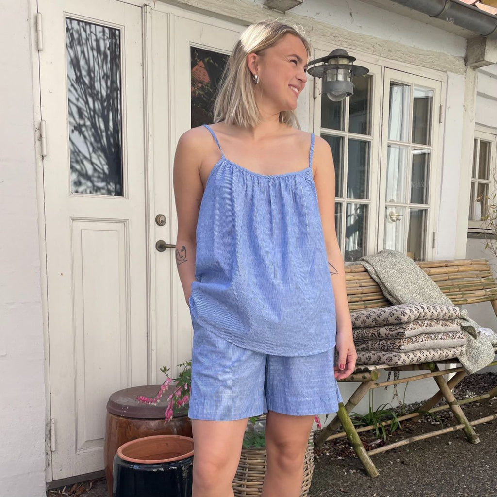 De nye Sydney Shorts i stribet blå og hvid er endnu en tidløs klassiker til din garderobe fra danske Frau. Shortsene er lavet i et enkelt design med vide ben, baglommer, bred elastik i taljen og bindebånd.