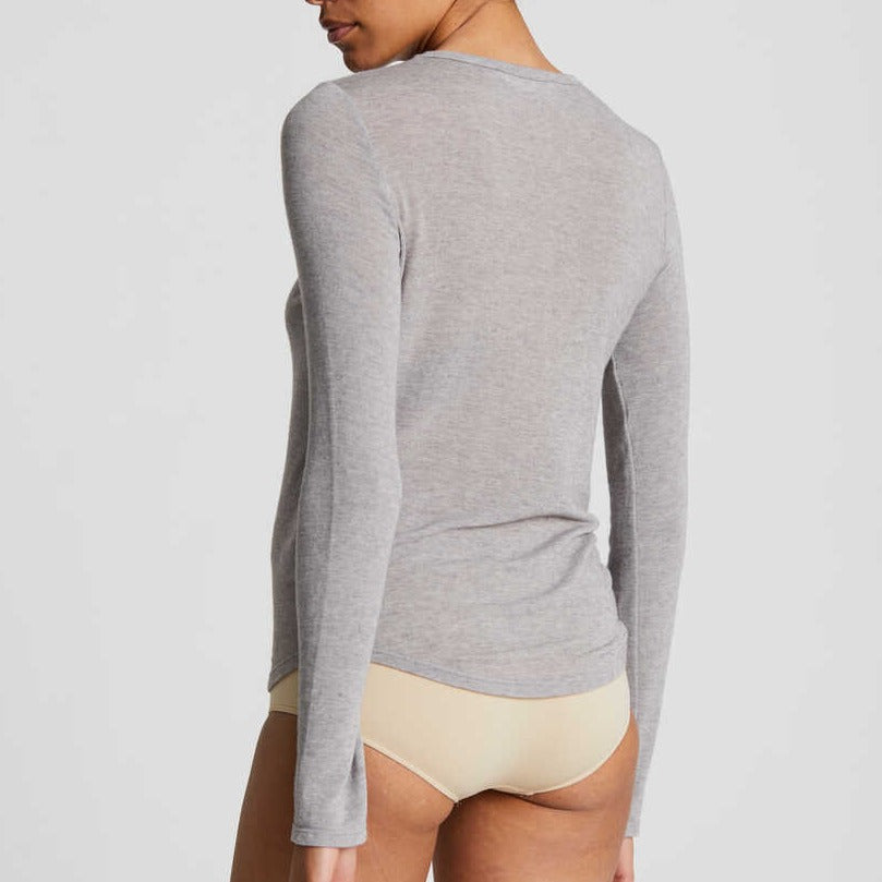 Den bæredygtige grå bluse i uld, er en fantastisk basisbluse, til brug alene, og især under striktrøjer eller andre tynde bluser, for at give lidt varme. Trøjen er kropsnær i snittet både på krop og ærmer og har en smuk flatterende og rund halsudskæring