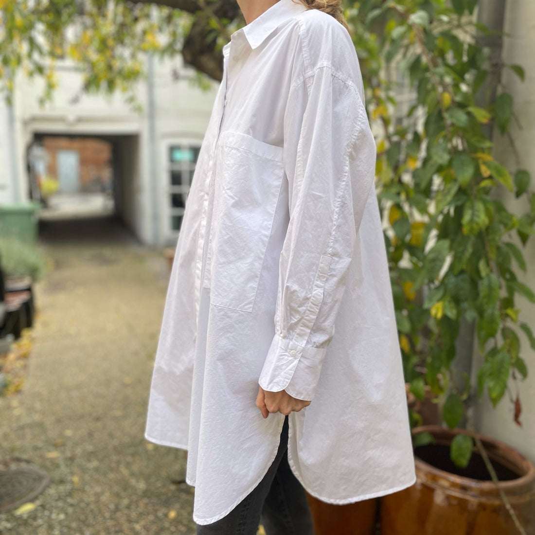 Den lange hvide bomuldsskjorte i er en perfekt hverdagsskjorte fra Frau. Skjorten er lidt længere bagpå og runder fint foran. Skjorten er gennemknappet, og er lavet i økologisk bomuldspoplin, som gør den åndbar og behagelig at have på. Størrelsen er one size