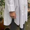 Den lange hvide bomuldsskjorte i er en perfekt hverdagsskjorte fra Frau. Skjorten er lidt længere bagpå og runder fint foran. Skjorten er gennemknappet, og er lavet i økologisk bomuldspoplin, som gør den åndbar og behagelig at have på. Størrelsen er one size 