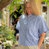NICE skjorte med korte ærmer og stor brystlomme er lavet i økologisk bomuld. Mærket er det danske FRAU og varianten her er i blå/hvid strib.